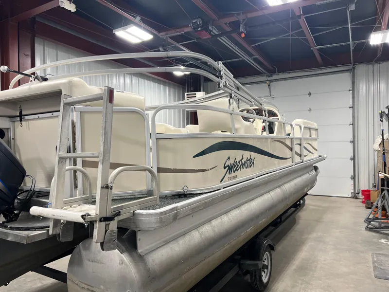 Slide: The Image of 2008 Sweetwater 2386 RE pontoon boat in a garage, side view. - 4