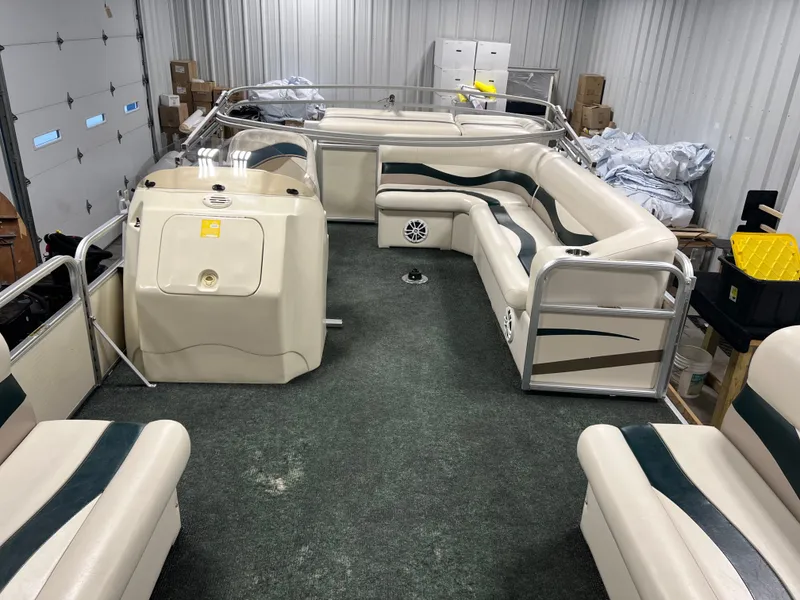 Slide: The Image of 2008 Sweetwater 2386 RE pontoon boat interior with seating and storage in a garage. - 9