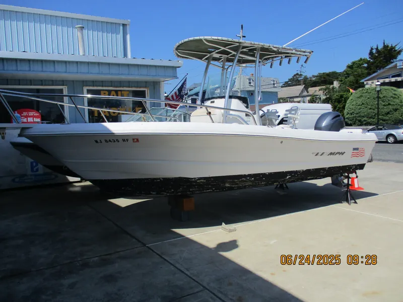 Slide: The Image of 2007 Triumph 21 Center Console boat displayed outdoors near a bait shop. - 10