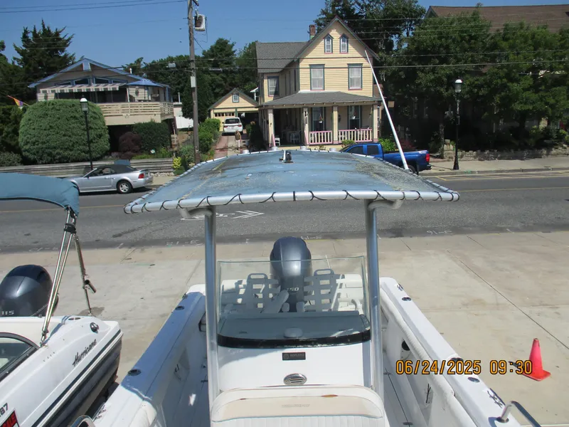 Slide: The Image of 2007 Triumph 21 Center Console boat parked on a street with houses in the background. - 20