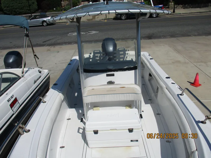 Slide: The Image of 2007 Triumph 21 Center Console boat with T-top and seating, parked on pavement. - 21