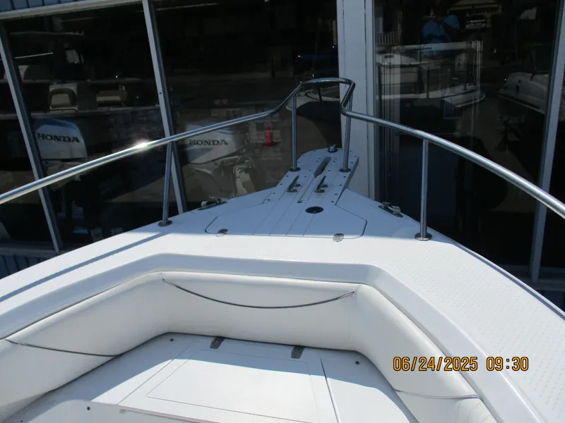Slide: The Image of 2007 Triumph 21 Center Console boat with white seating and railing, docked near Honda engines. - 22