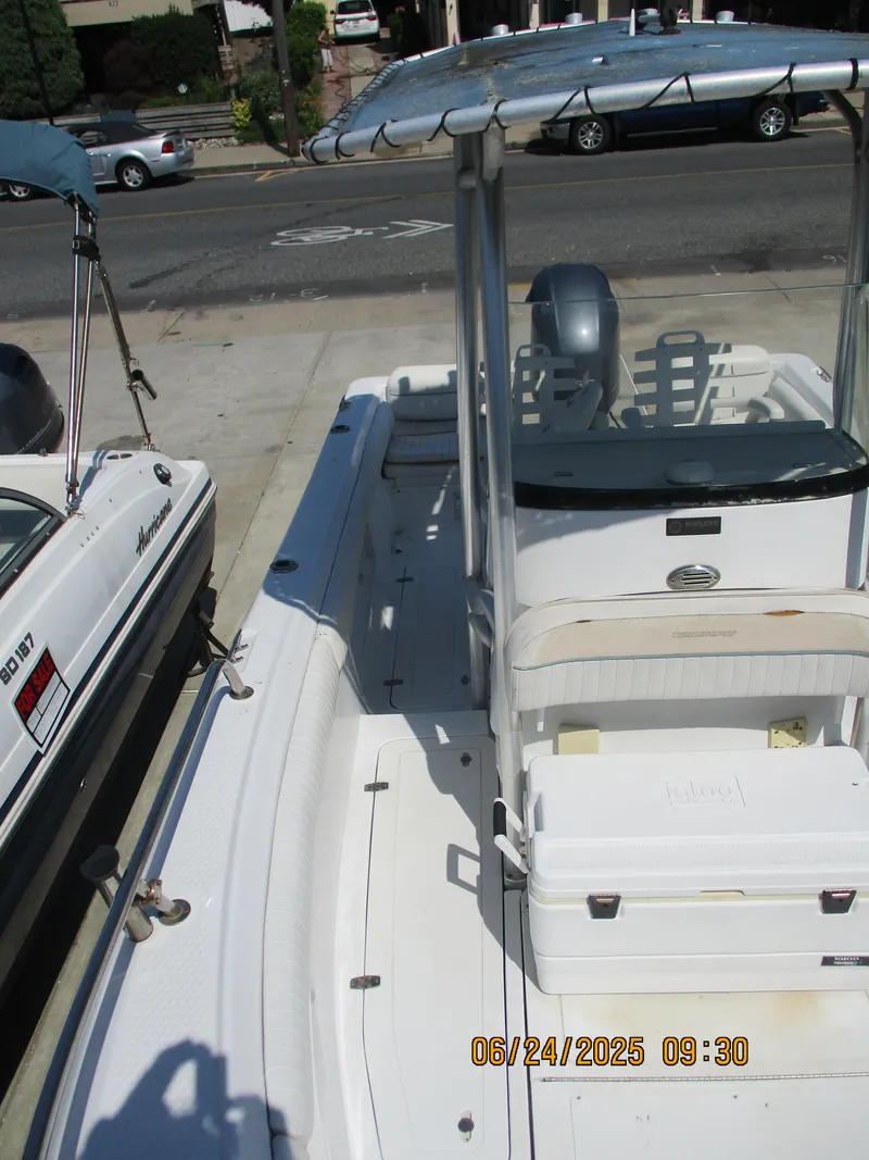 Slide: The Image of 2007 Triumph 21 Center Console boat parked on a street, featuring a T-top and seating. - 26