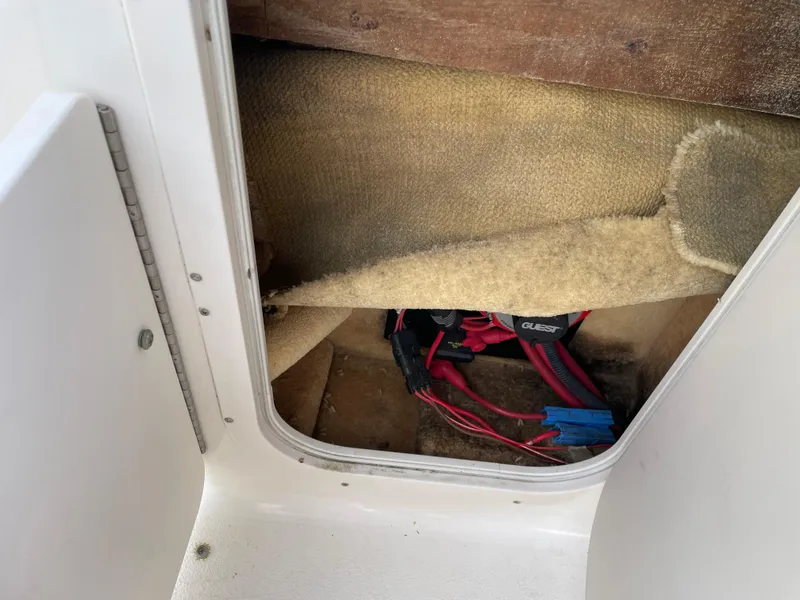 Slide: The Image of 2004 Chaparral Signature 240 boat interior storage compartment with wiring visible. - 26