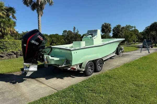 Slide: The Image of Custom Vernese V23 boat, 2021 model, on trailer with powerful outboard motor, parked outdoors. - 15