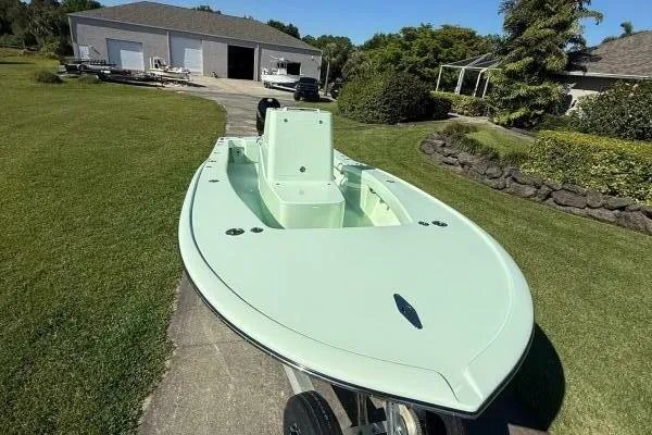 Slide: The Image of Custom Vernese V23 boat, 2021 model, mint green, parked on driveway near garage and garden. - 2