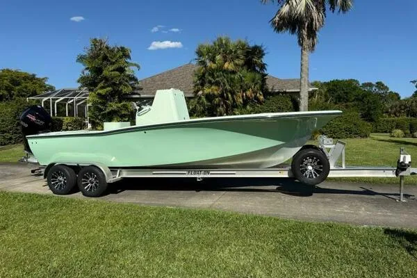 Slide: The Image of Custom Vernese V23 boat on trailer, parked in a lush garden setting, 2021 model. - 27