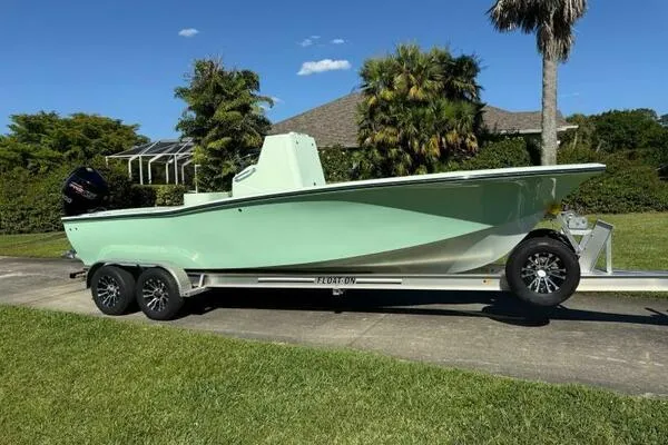 Slide: The Image of Custom Vernese V23 boat on trailer, 2021 model, parked outdoors with lush greenery. - 5