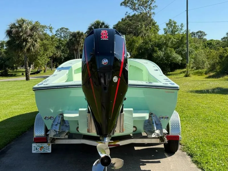 Slide: The Image of Custom Vernese V23 boat, 2021 model, with powerful outboard motor on a trailer in a lush setting. - 7