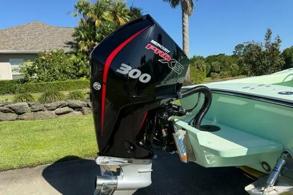 Slide: The Image of Outboard motor on Custom Vernese V23 boat, 2021 model, in a sunny residential setting. - 8
