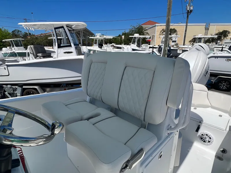 Slide: The Image of 2025 Sea Hunt Ultra 235 SE boat with white cushioned seating and steering wheel. - 4