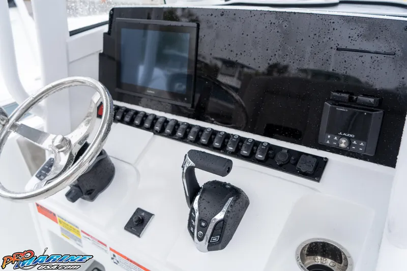 Slide: The Image of 2025 Sea Hunt Ultra 235 SE boat dashboard with steering wheel and controls. - 5