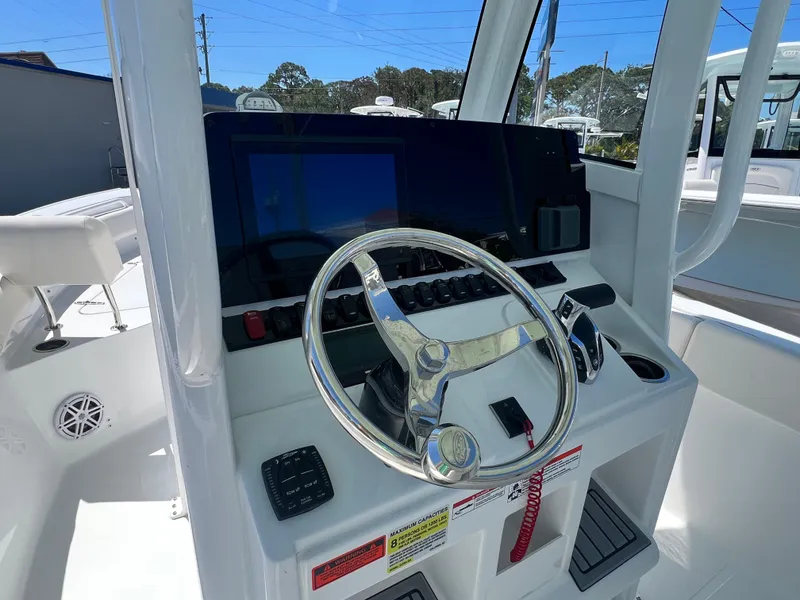 Slide: The Image of 2025 Sea Hunt Ultra 235 SE boat dashboard with steering wheel and controls. - 8