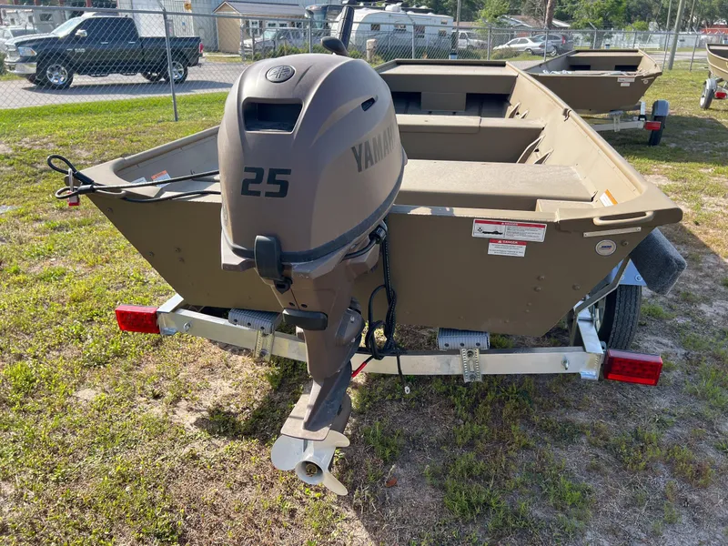 Slide: The Image of 2025 G3 Gator Tough 1544 LW boat with Yamaha 25 outboard motor, parked on grass. - 2