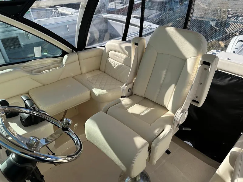 Slide: The Image of 2022 Grady-White Express 330 boat interior with beige seating and steering wheel. - 19