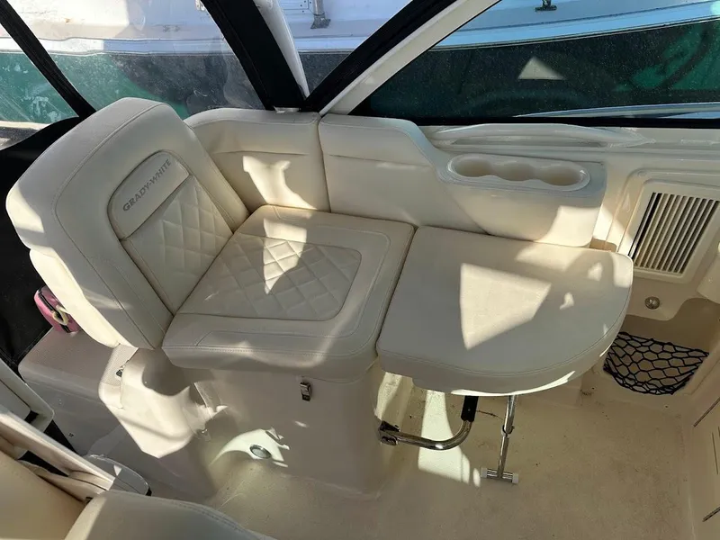 Slide: The Image of 2022 Grady-White Express 330 boat interior with cushioned seating and cup holders. - 20