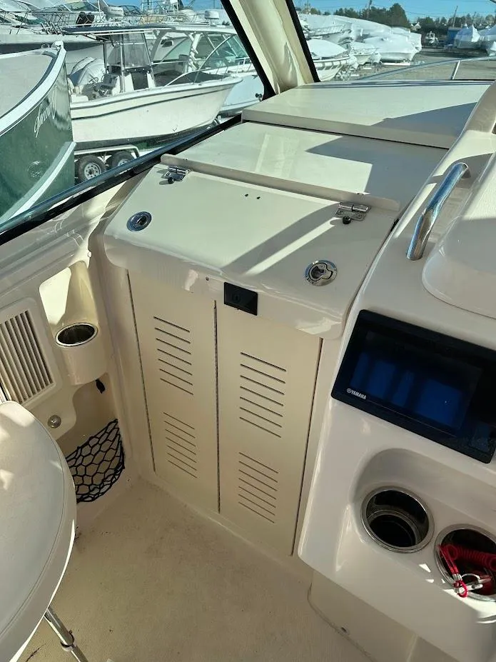 Slide: The Image of 2022 Grady-White Express 330 boat interior with control panel and storage compartments. - 25
