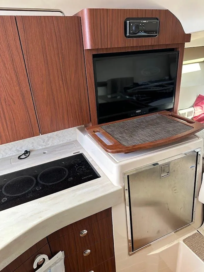 Slide: The Image of 2022 Grady-White Express 330 interior with stove, TV, and fridge. - 32