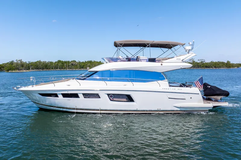 Slide: The Image of 2012 Prestige 500 Fly yacht cruising on calm waters under a clear blue sky. - 0