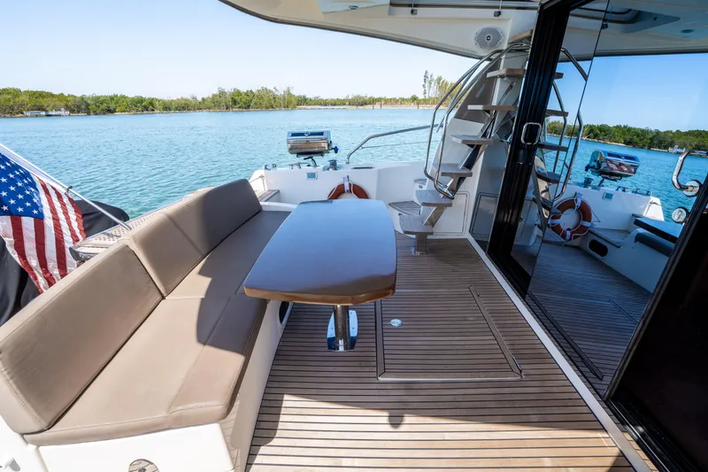 Slide: The Image of Luxurious 2012 Prestige 500 Fly yacht deck with seating, table, and scenic water view. - 12