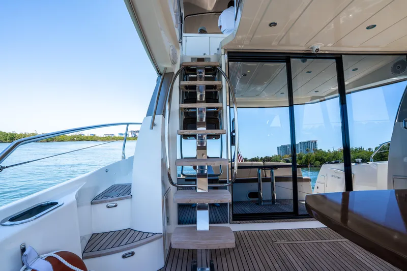Slide: The Image of Prestige 500 Fly 2012 yacht interior with wooden stairs and glass doors, overlooking water. - 16