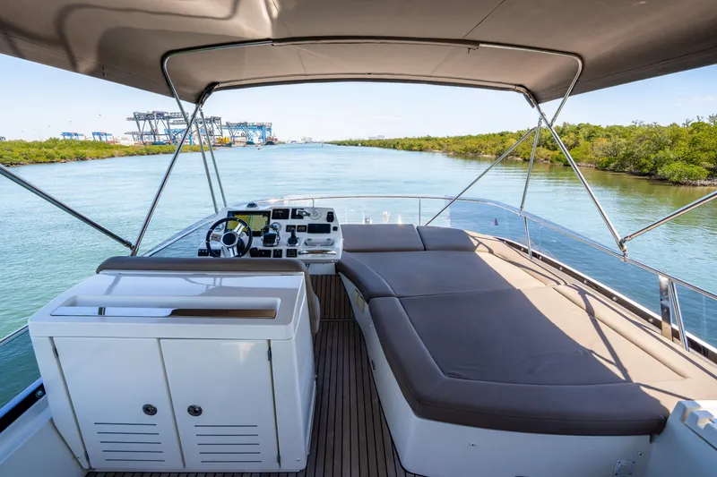 Slide: The Image of Flybridge view of 2012 Prestige 500 Fly yacht, featuring spacious seating and navigation controls. - 19