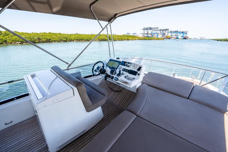 Slide: The Image of Flybridge of 2012 Prestige 500 Fly yacht with helm station and seating, overlooking serene waters. - 20