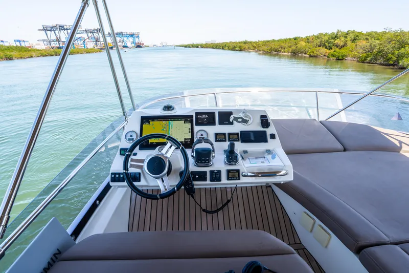 Slide: The Image of Prestige 500 Fly 2012 yacht helm with navigation equipment on a serene waterway. - 21