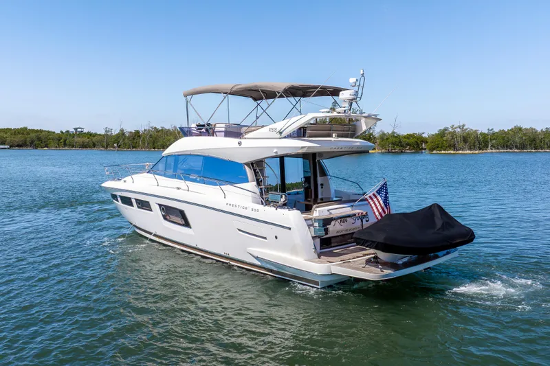 Slide: The Image of 2012 Prestige 500 Fly yacht cruising on a serene lake with clear blue skies. - 4