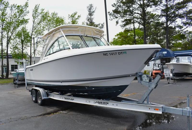 Slide: The Image of 2012 Pursuit DC 265 Dual Console boat on trailer, parked outdoors. - 1