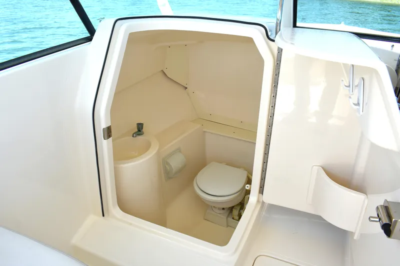 Slide: The Image of 2012 Pursuit DC 265 Dual Console boat interior with compact marine toilet. - 17