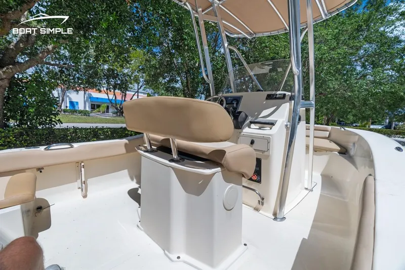 Slide: The Image of 2022 Scout 195 Sportfish boat interior with beige seating and steering console. - 8