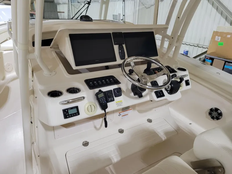 Slide: The Image of 2019 Grady-White Canyon 336 boat dashboard with steering wheel and electronic controls. - 16