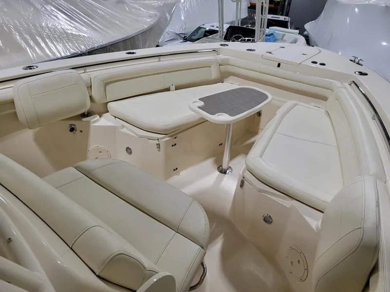 Slide: The Image of 2019 Grady-White Canyon 336 boat interior with beige seating and small table. - 25