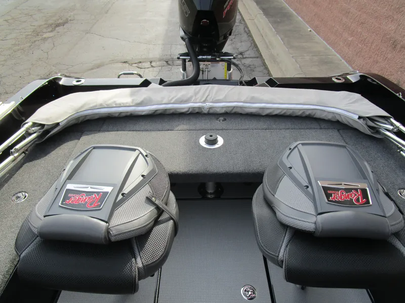 Slide: The Image of 2024 Ranger 621 CUP boat interior with padded seats and motor view. - 7