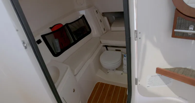 Slide: The Image of 2018 Grady-White Freedom 307 boat interior with toilet and seating area. - 14