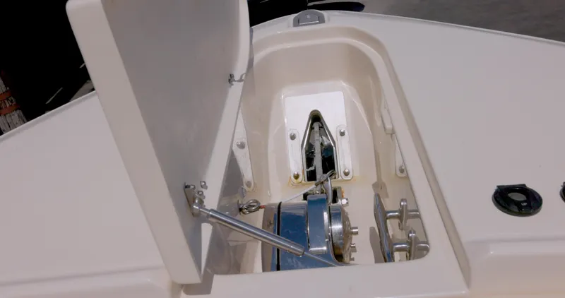 Slide: The Image of Anchor compartment of 2018 Grady-White Freedom 307 boat, featuring a winch and storage area. - 15