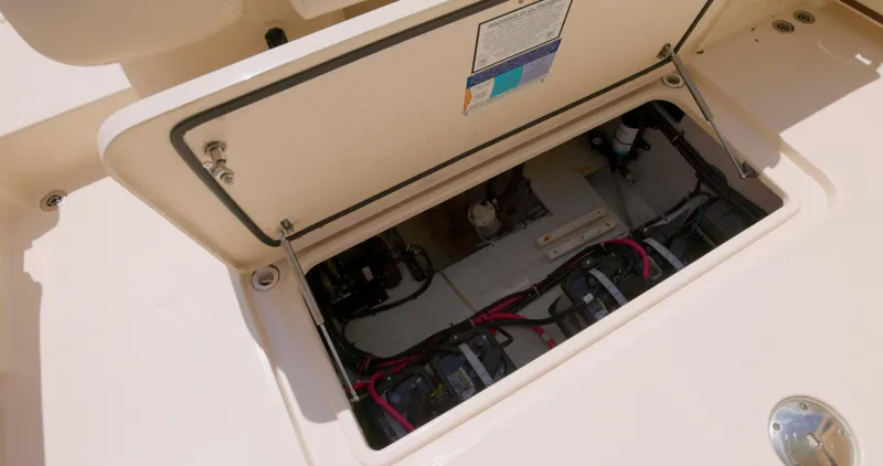 Slide: The Image of 2018 Grady-White Freedom 307 boat storage compartment with visible wiring and components. - 16