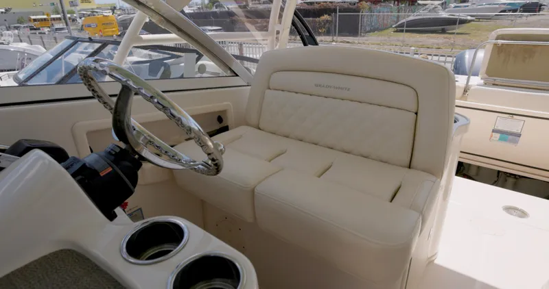 Slide: The Image of 2018 Grady-White Freedom 307 boat interior with steering wheel and cushioned seating. - 3