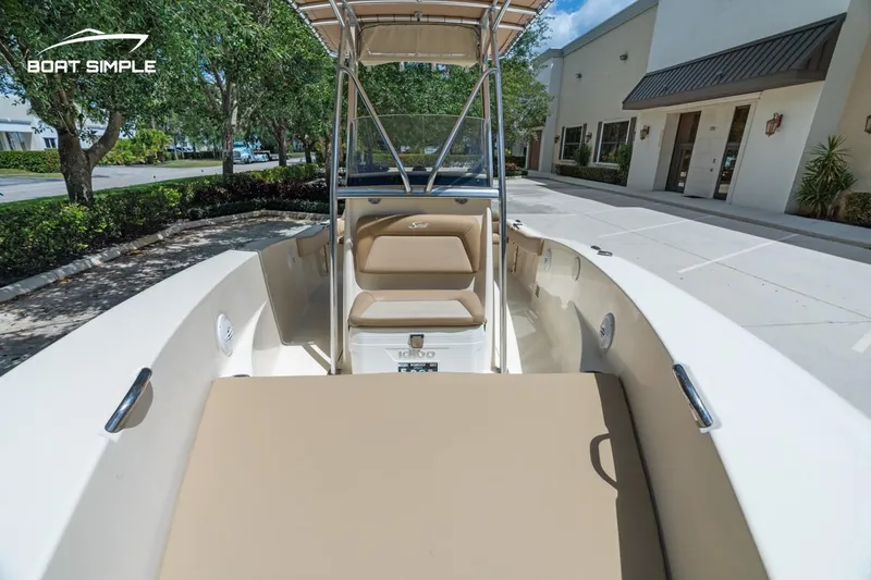 Slide: The Image of 2022 Scout 195 Sportfish boat with seating, parked outdoors near buildings. - 14