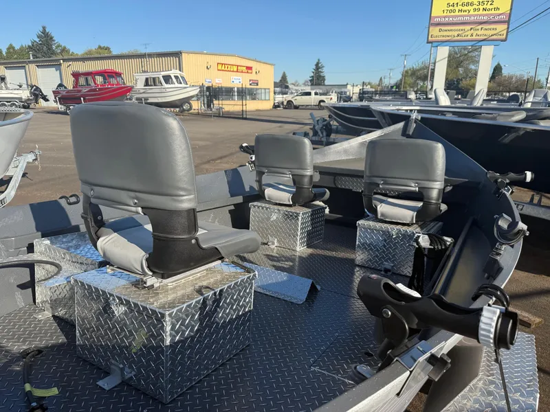 Slide: The Image of 2025 Custom Driftwood Boats Drifter 18.5 with gray seats and aluminum flooring in a boatyard. - 8