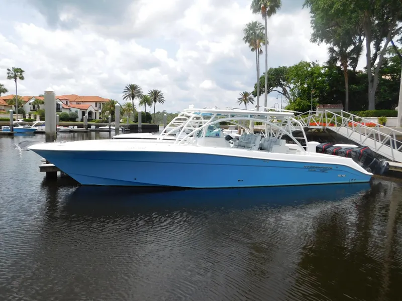 Slide: The Image of 2013 Hydra-Sports 4200 Siesta boat docked on calm water, surrounded by palm trees. - 2