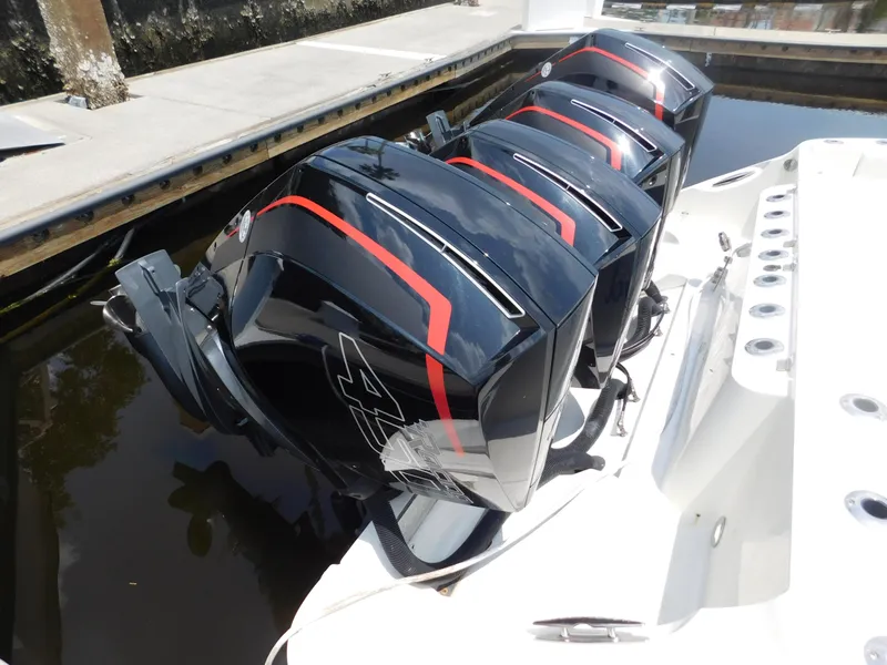 Slide: The Image of Four powerful outboard engines on a 2013 Hydra-Sports 4200 Siesta boat docked by the water. - 5