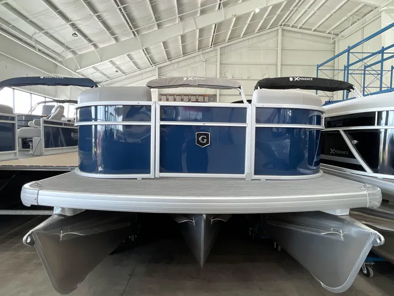 Slide: The Image of 2025 Godfrey EX2086SBX pontoon boat in showroom, blue and silver design. - 0