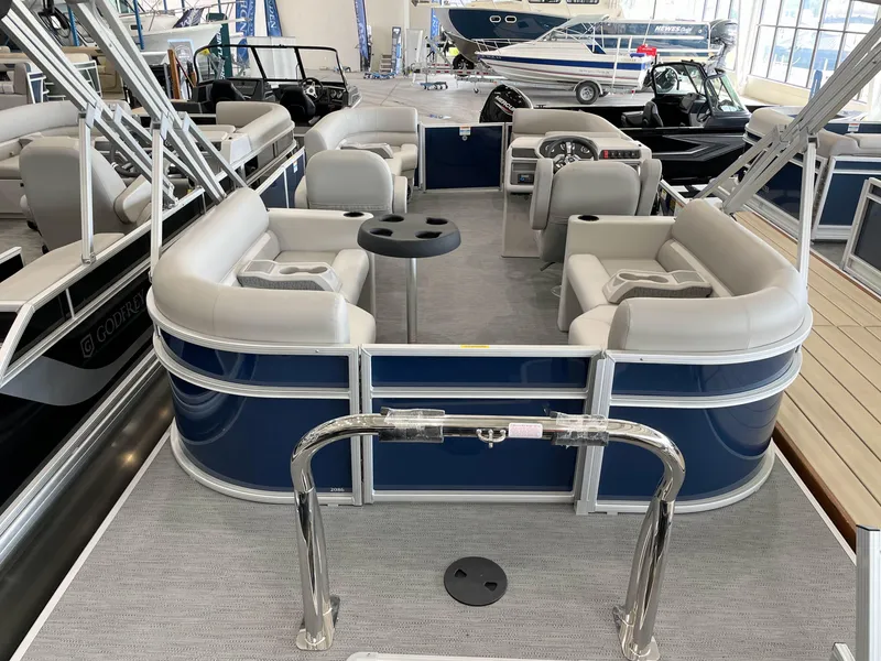 Slide: The Image of 2025 Godfrey EX2086SBX pontoon boat with spacious seating and modern design in showroom. - 18