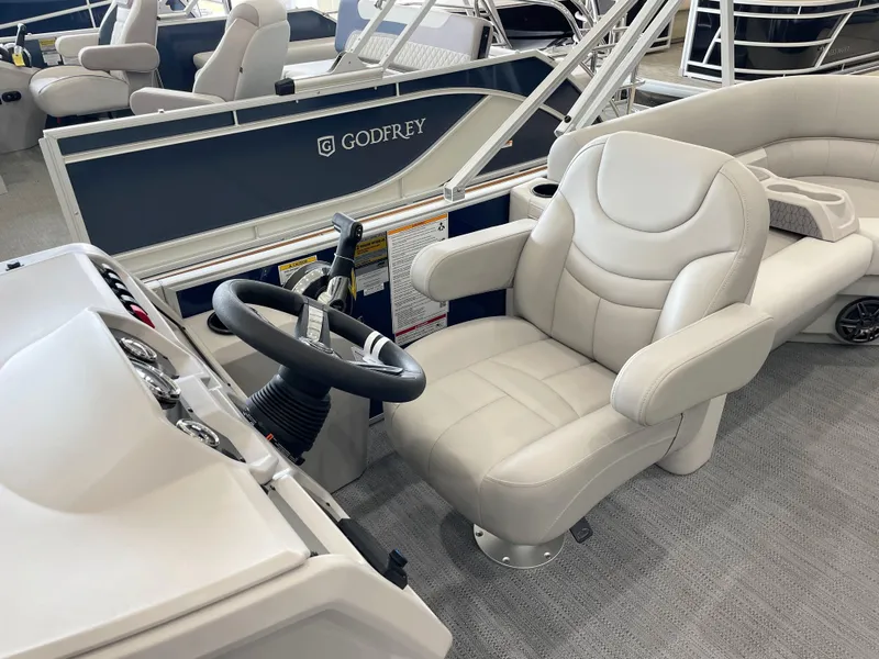 Slide: The Image of Captain's chair and helm of 2025 Godfrey EX2086SBX pontoon boat, featuring plush seating. - 9