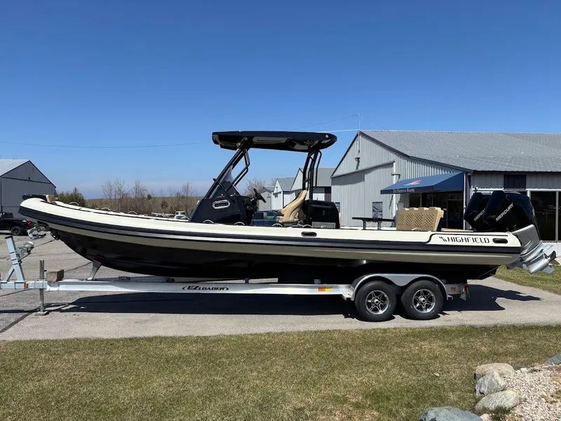 Slide: The Image of 2025 Highfield Sport 900 boat on trailer, parked outdoors near a building. - 1