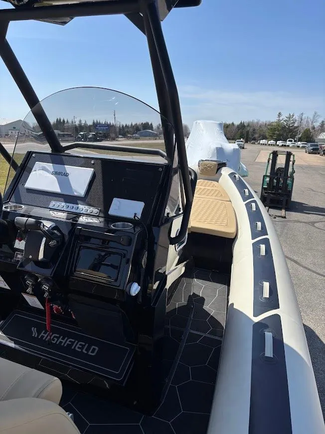 Slide: The Image of 2025 Highfield Sport 900 boat with sleek design and modern dashboard, parked outdoors. - 10