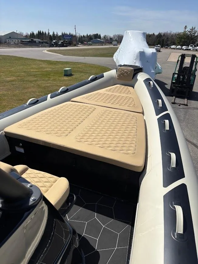 Slide: The Image of 2025 Highfield Sport 900 boat with beige seating and sleek design on display outdoors. - 13