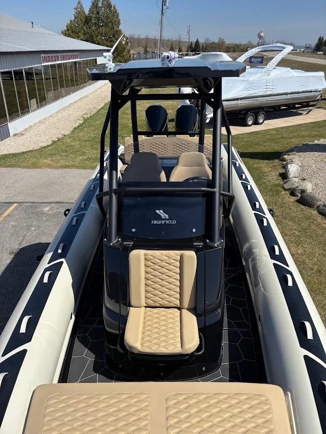 Slide: The Image of 2025 Highfield Sport 900 boat with beige seating and sleek design, displayed outdoors. - 16